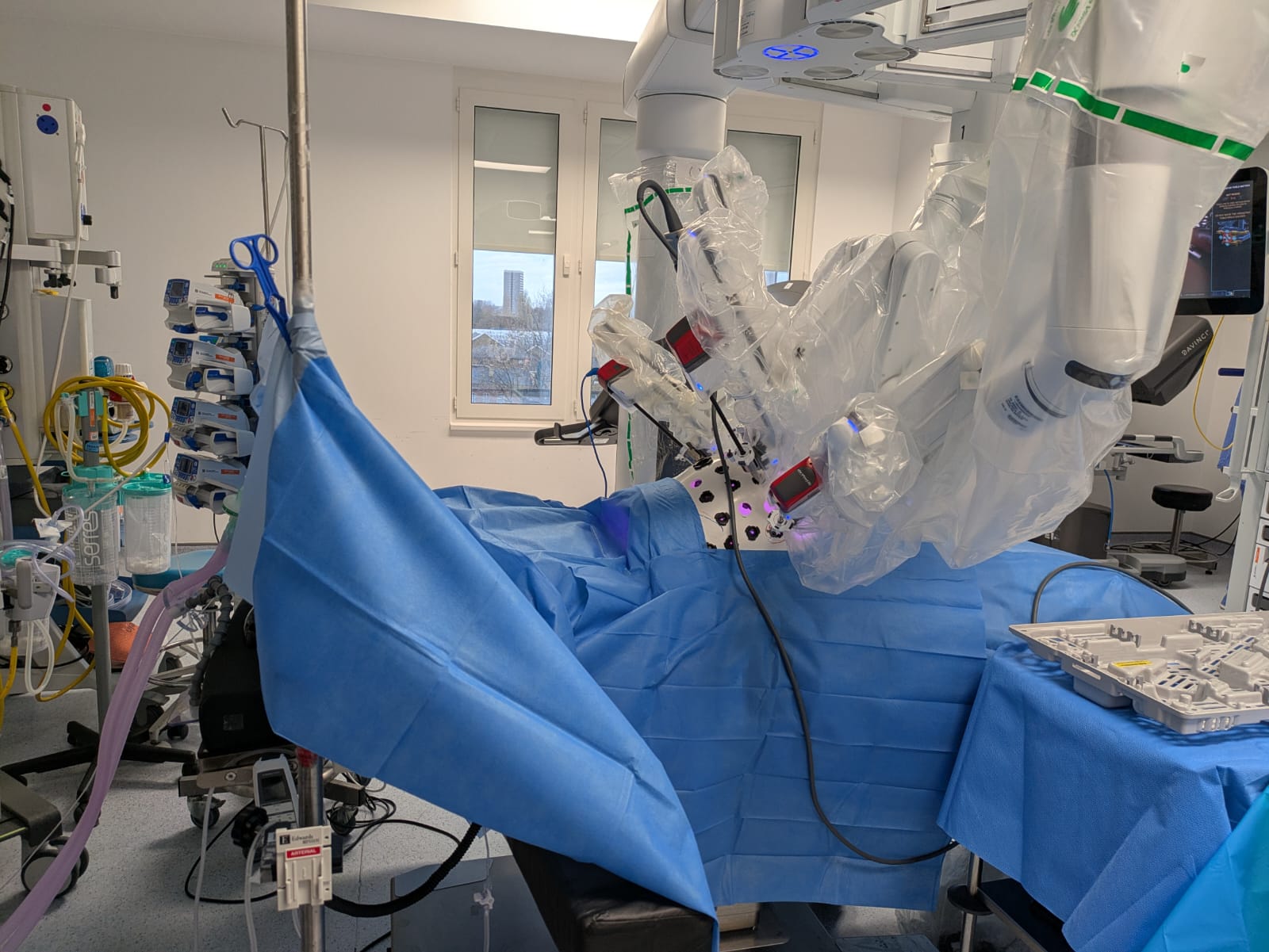 Surgeon seated at Da Vinci robotic console operating controls